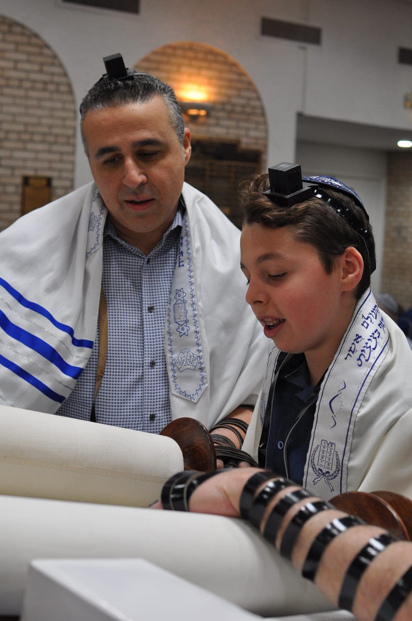 Father and son reading from the Torah together