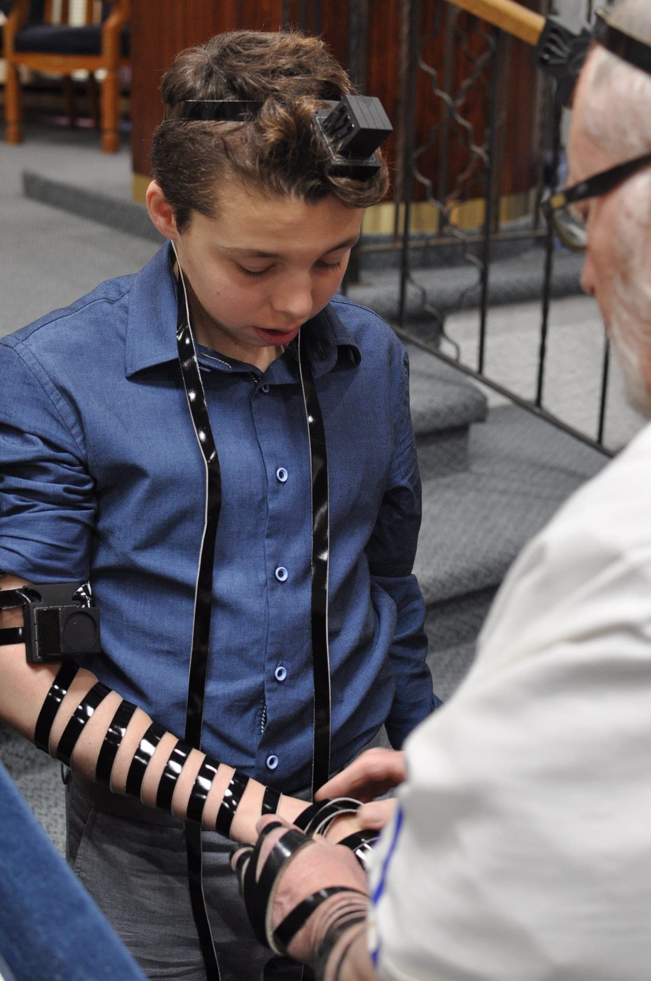 Teenager preparing to lay tefillin before his bar mitzvah