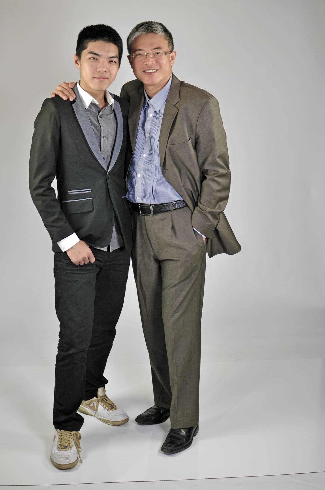 Father and teenage son in a full-length studio portrait