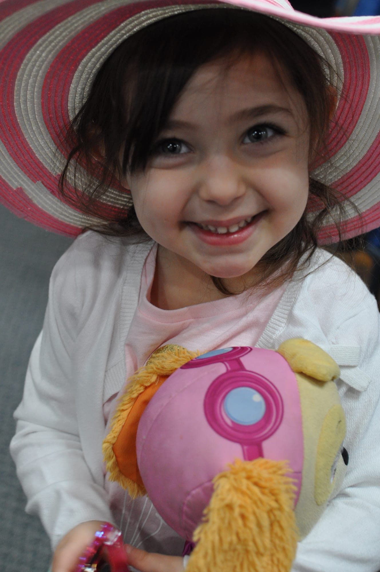 Young girl in a striped straw hat holding her doll