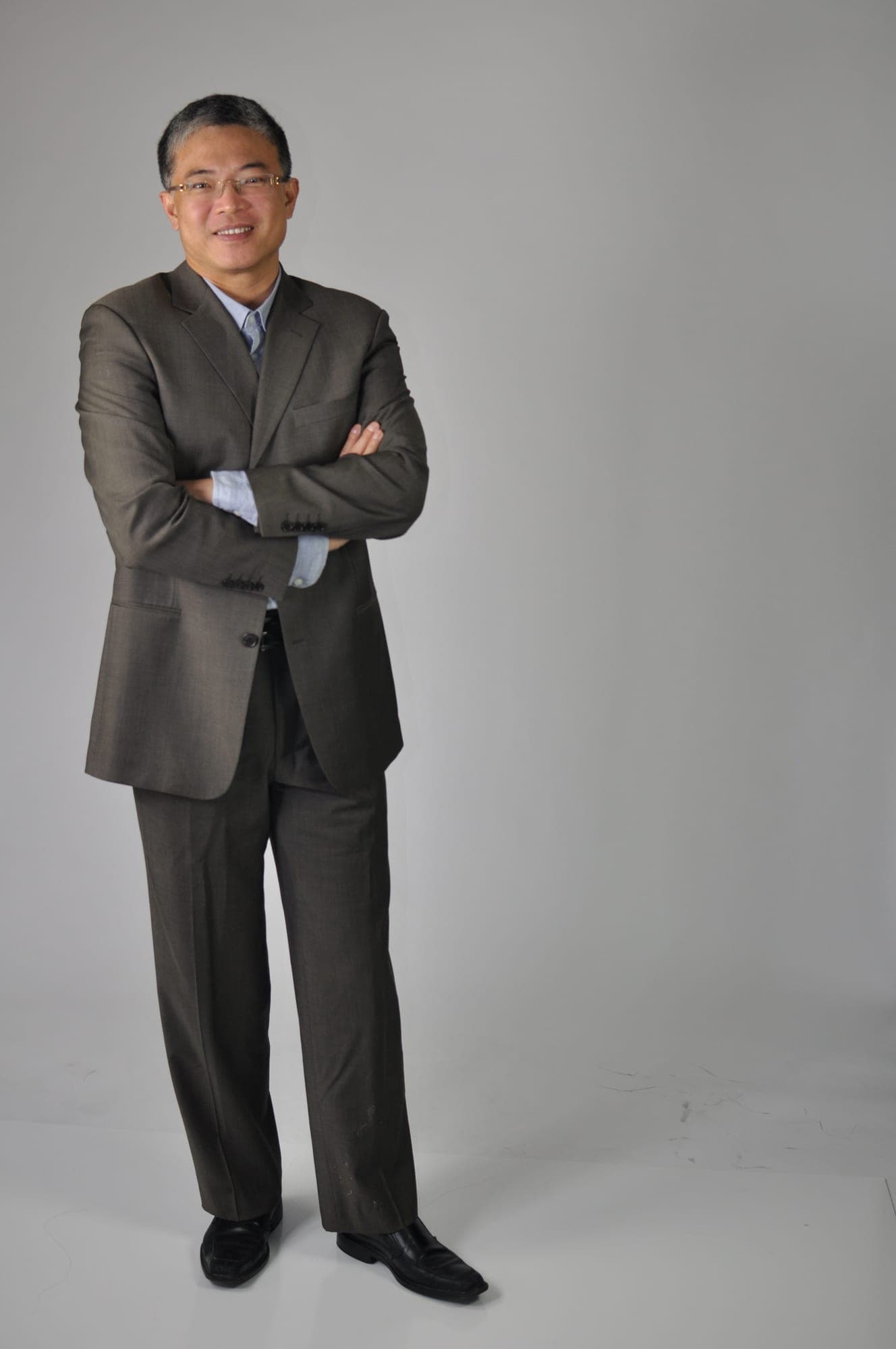 Full-length studio portrait of a businessman with arms crossed
