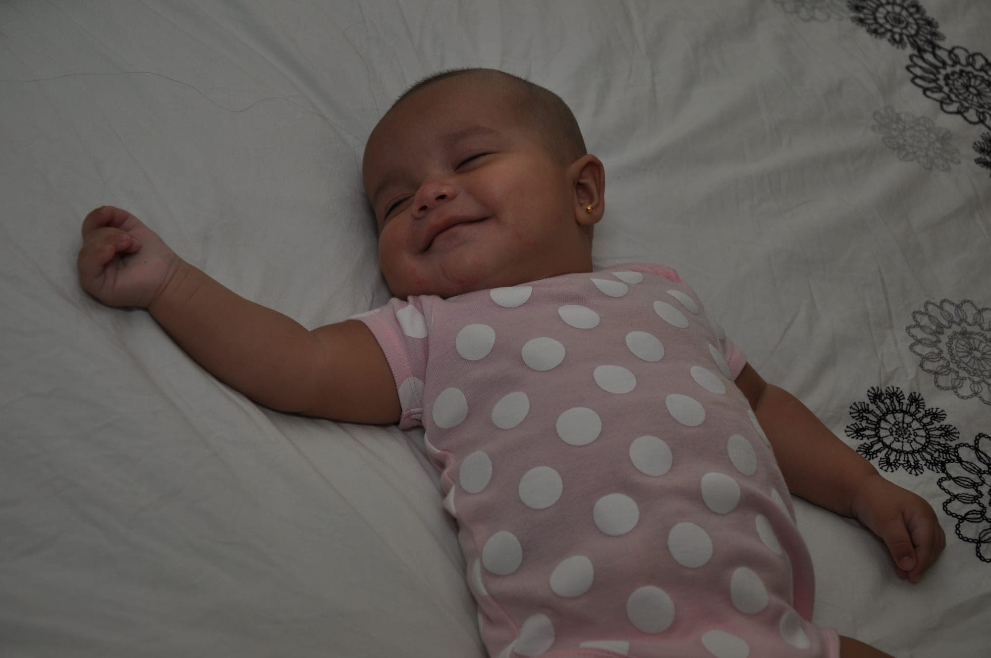 Newborn sleeping peacefully in a polka-dot outfit