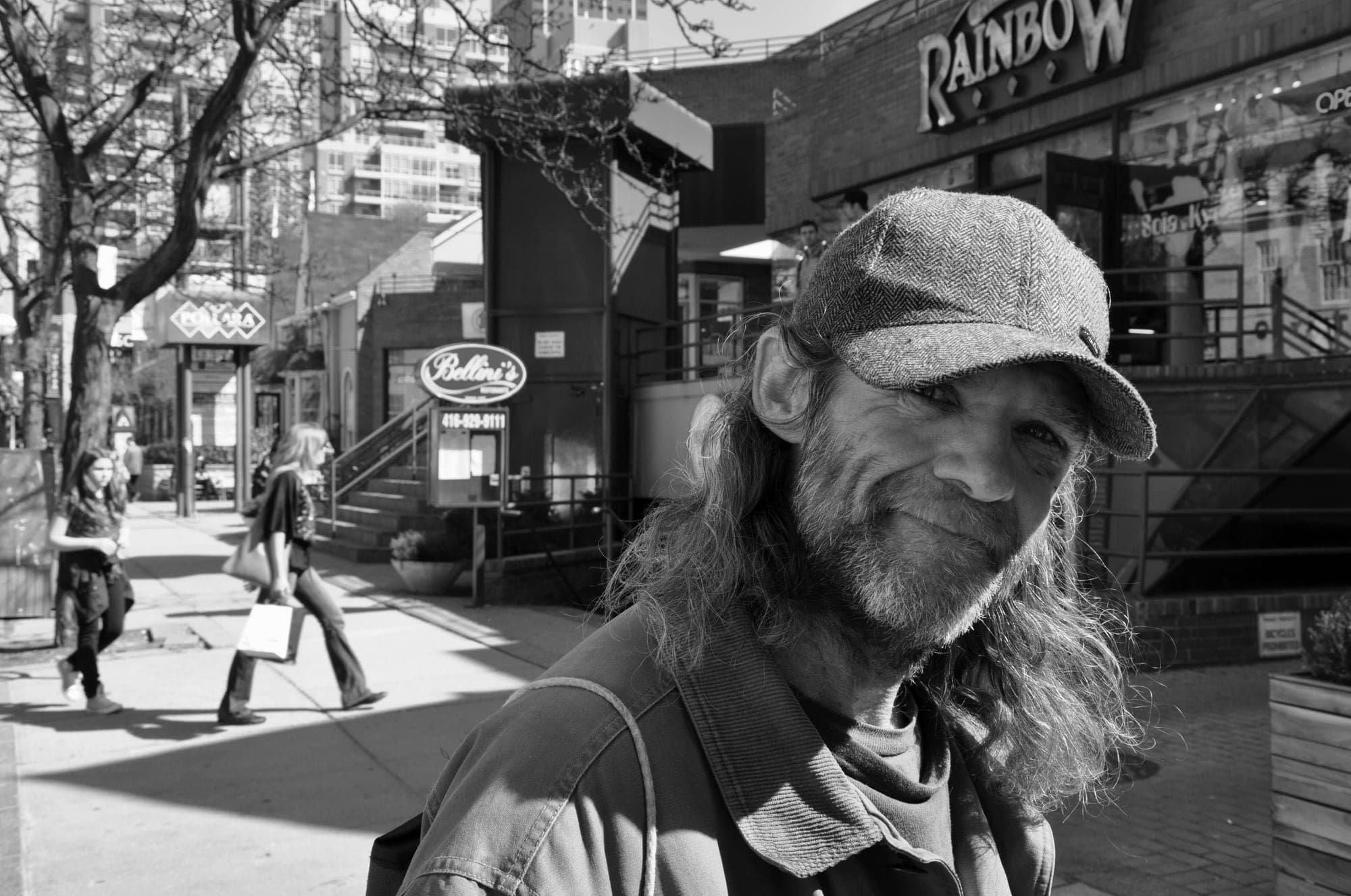 Black and white street portrait of a man on a city sidewalk