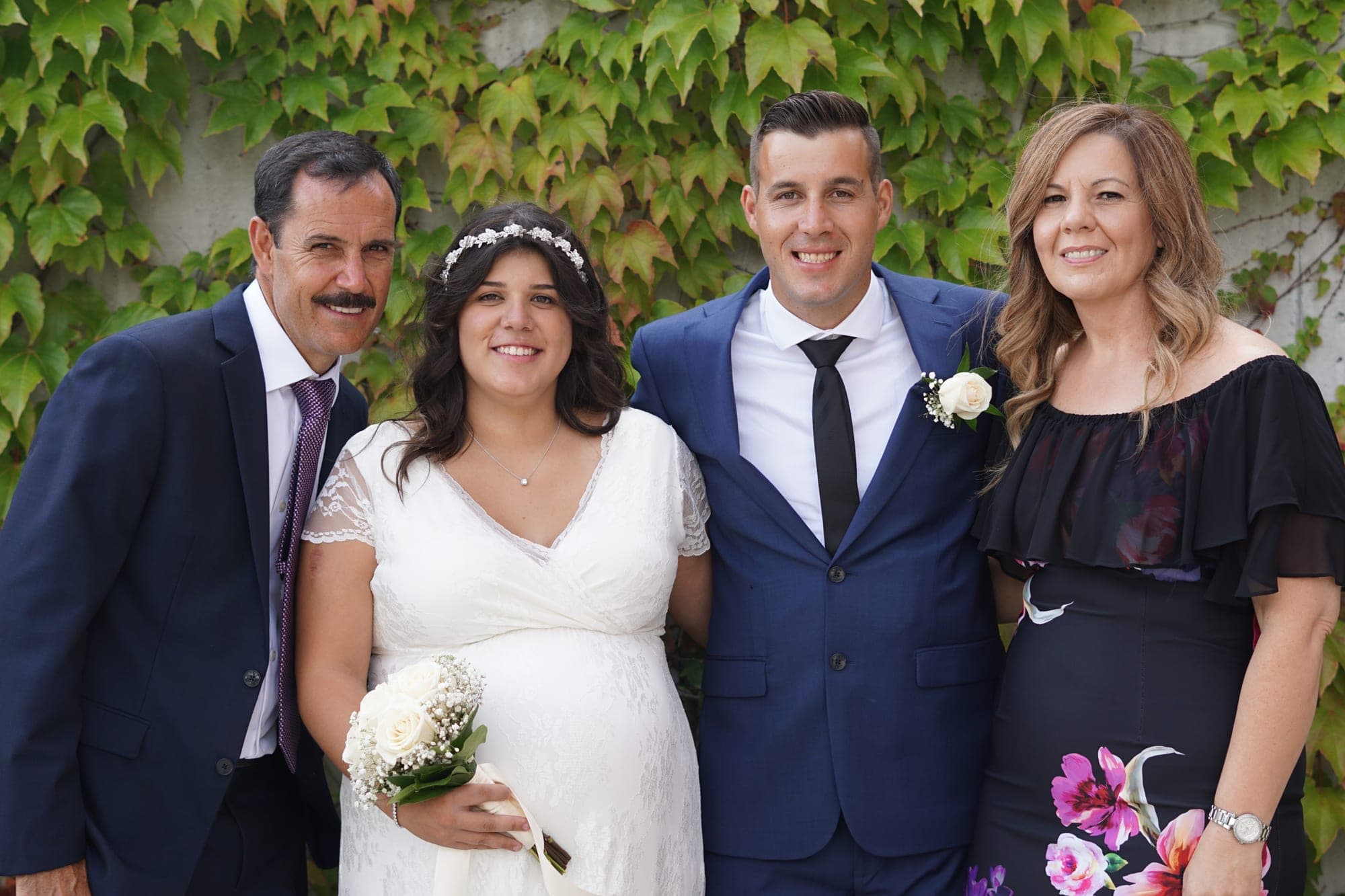 Bridal party of four in front of an ivy-covered wall