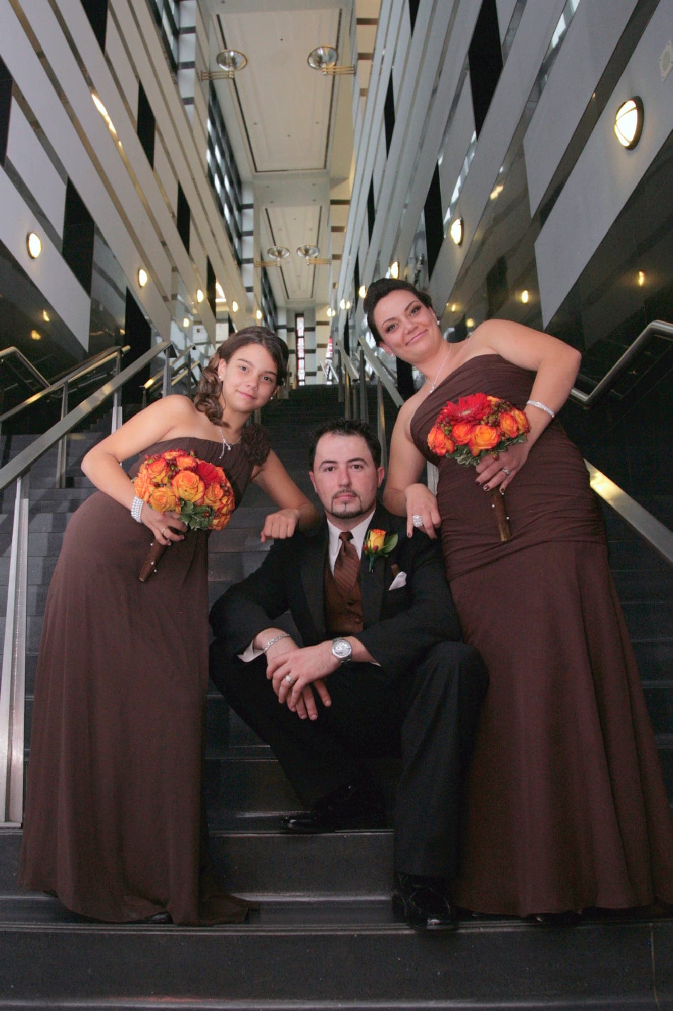 Bridal party posed on a staircase in chocolate-brown dresses
