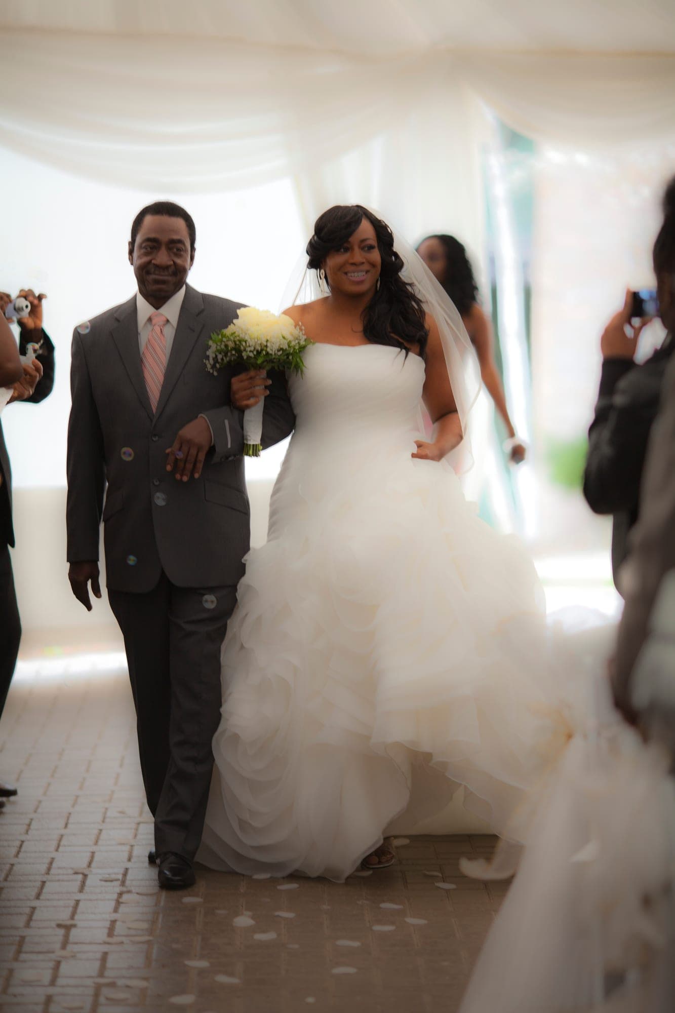 Bride in a full tulle gown walking out with her groom after the ceremony