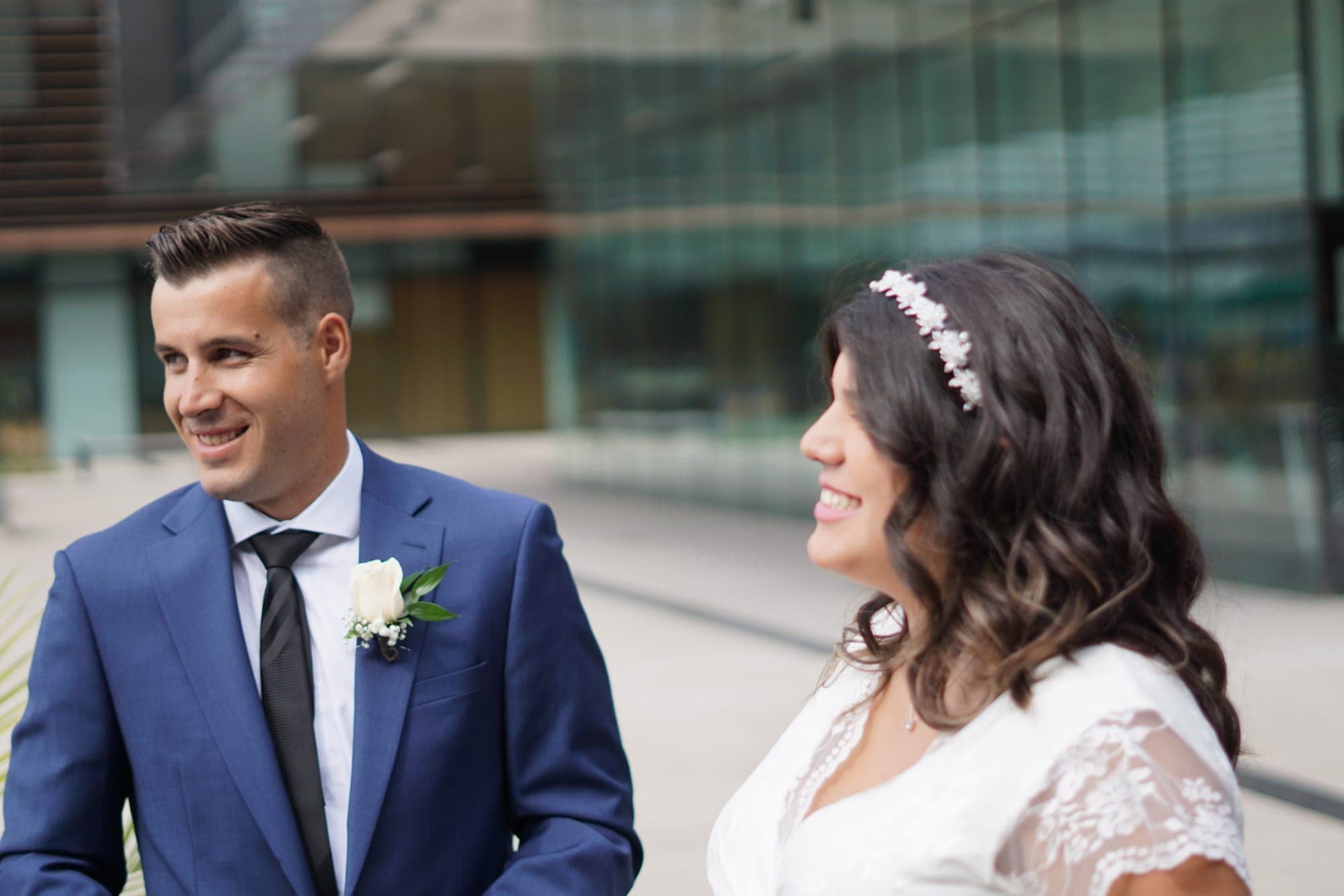 Newlyweds walking together across a modern city plaza