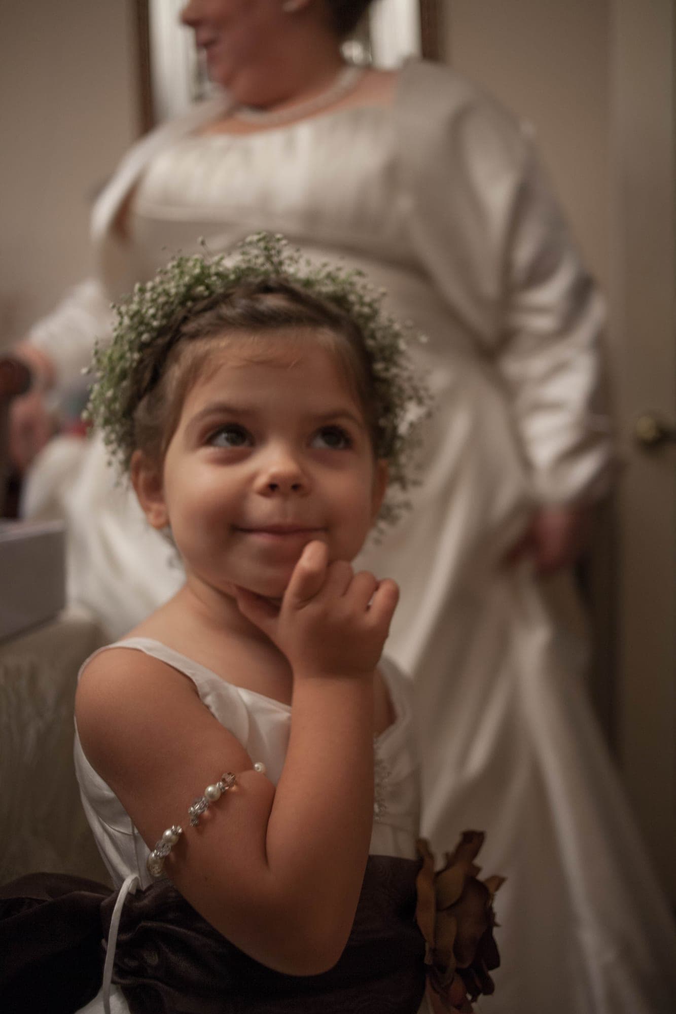 Flower girl wearing a baby's breath crown beside the bride