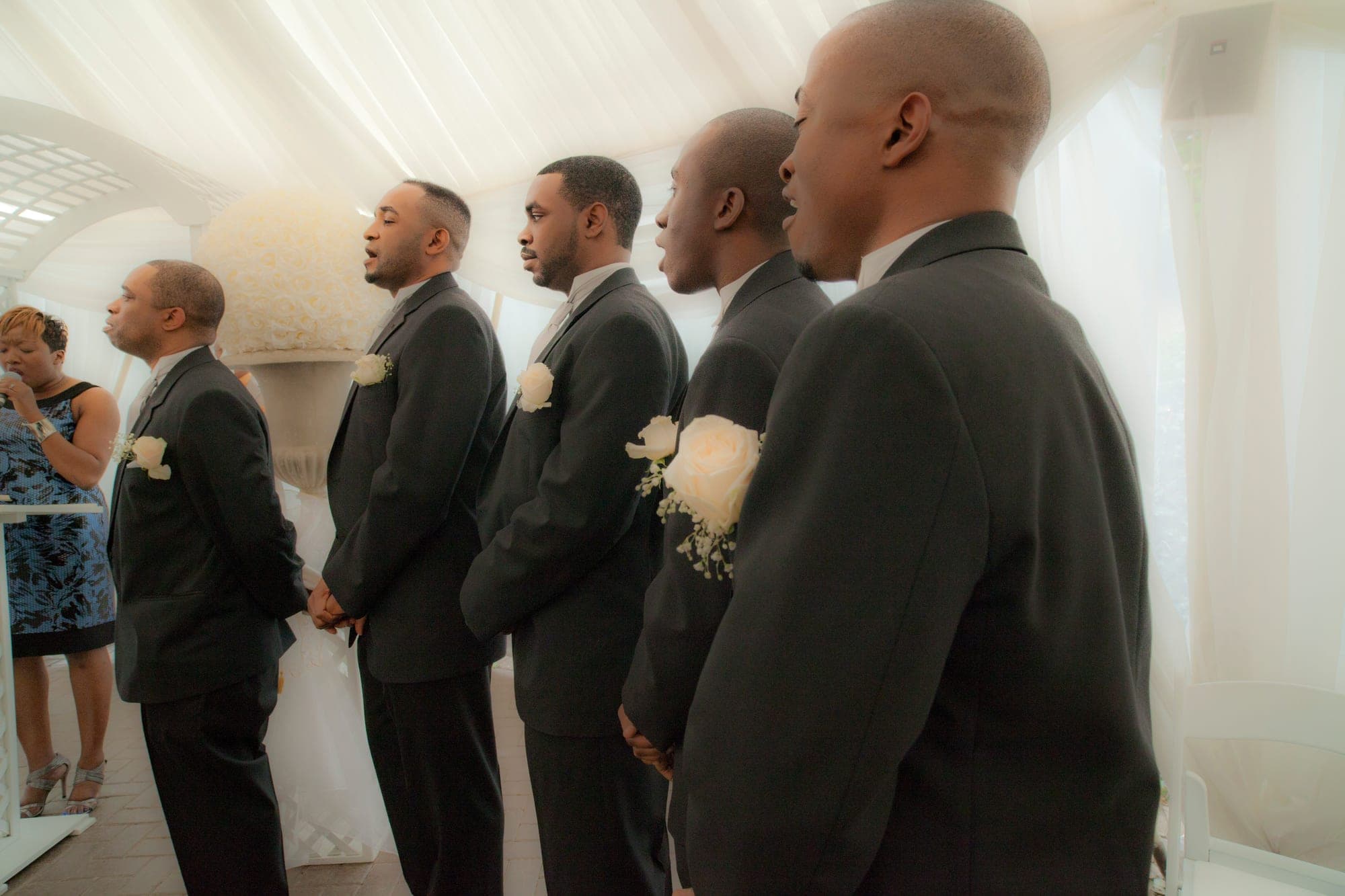 Groomsmen lined up in grey suits with white rose boutonnieres
