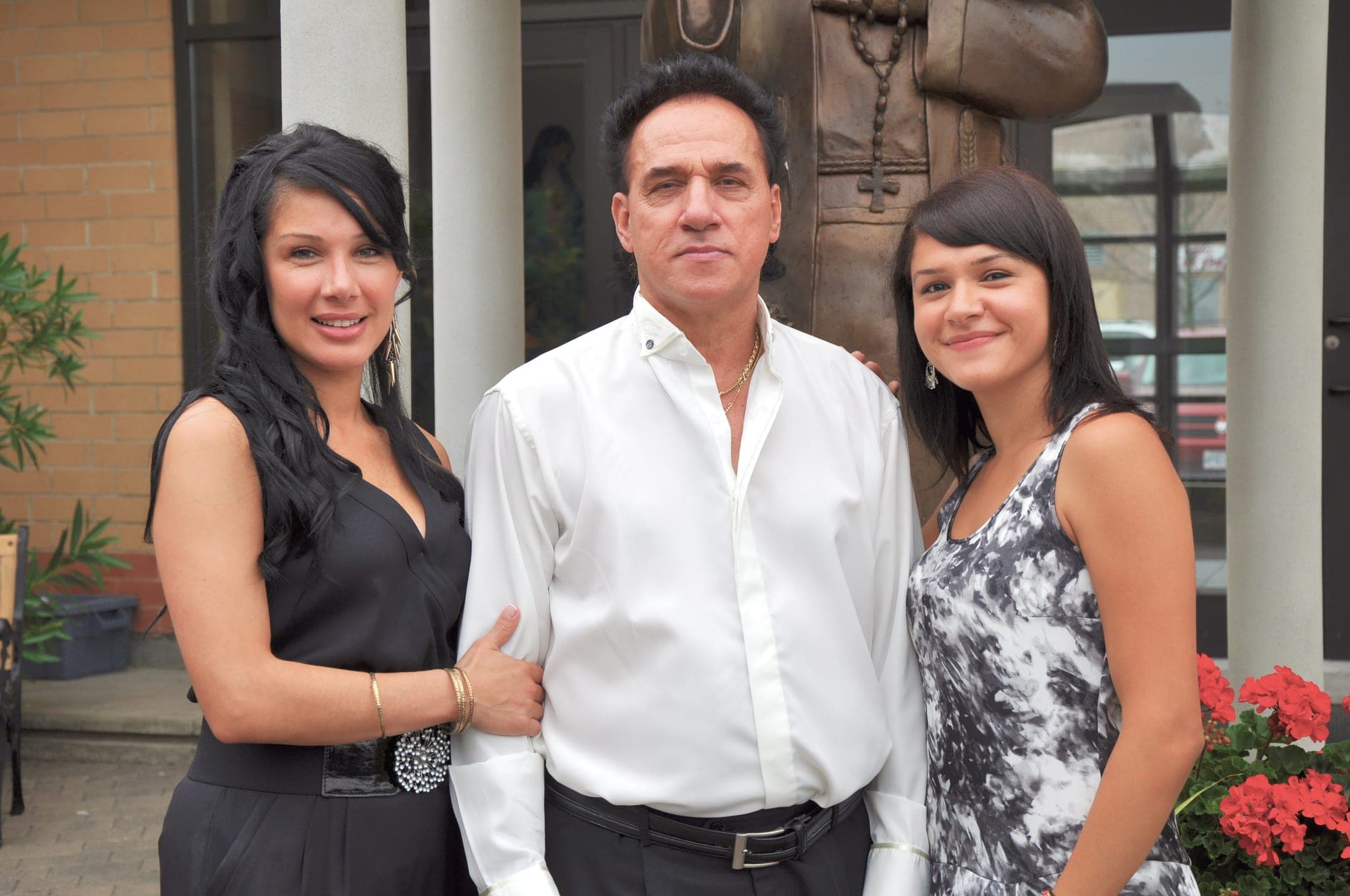 Father photographed outdoors with his two daughters on a family session