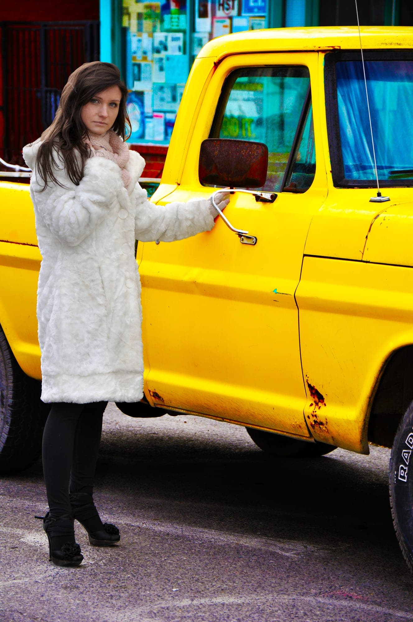 Editorial street portrait of a woman beside a yellow pickup truck