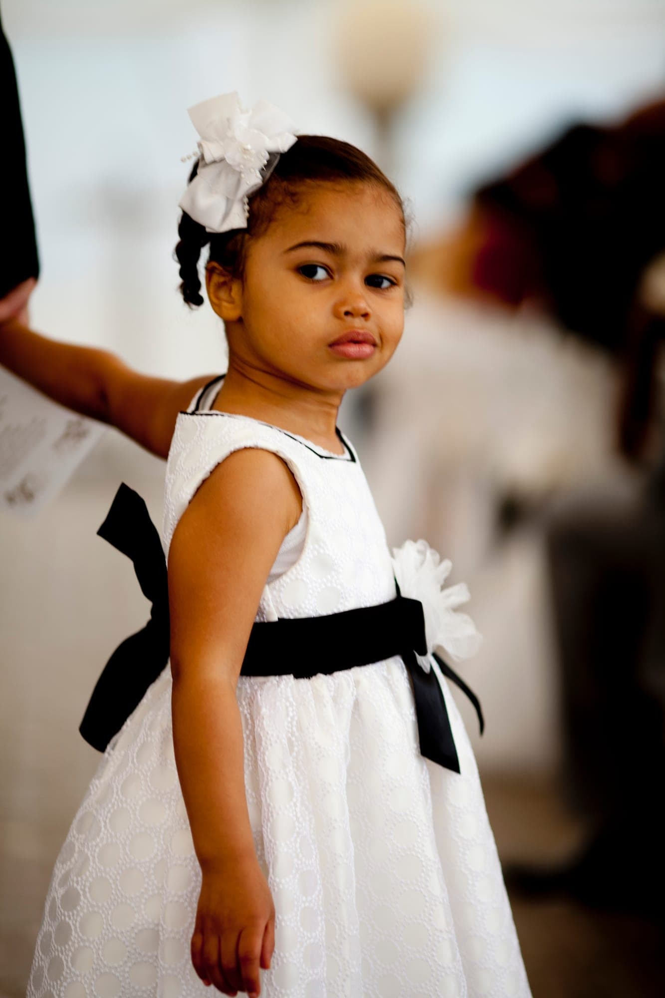 Flower girl in a white dress walking down the aisle at a Toronto wedding